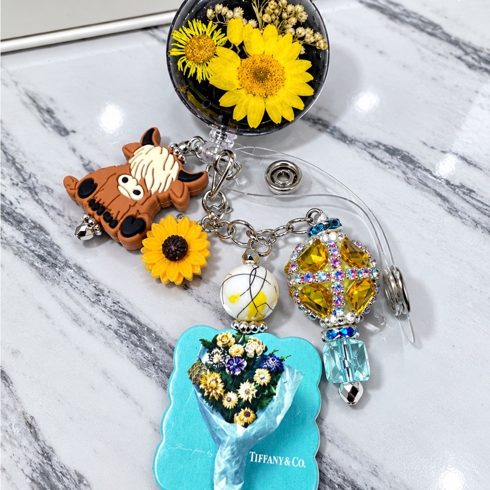 Tiffany & Co. Blue Floral Charm Badge Reel with Yellow Sunflower Accents